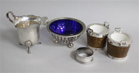 A pair of silver plated mounted condiments modelled as two handled buckets, a silver cream jug, bowl and napkin ring.